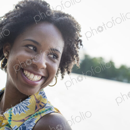 A woman smiling and laughing on a lake shore. A woman smiling and laughing on a lake shore.