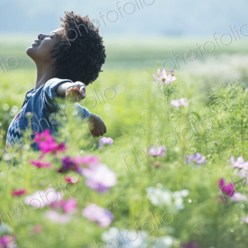 A woman standing among the flowers with her arms outstretched. Pink and white cosmos…