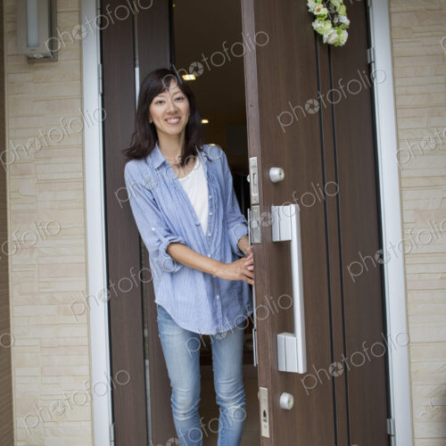 A woman standing at her front door. A woman standing at her front door.