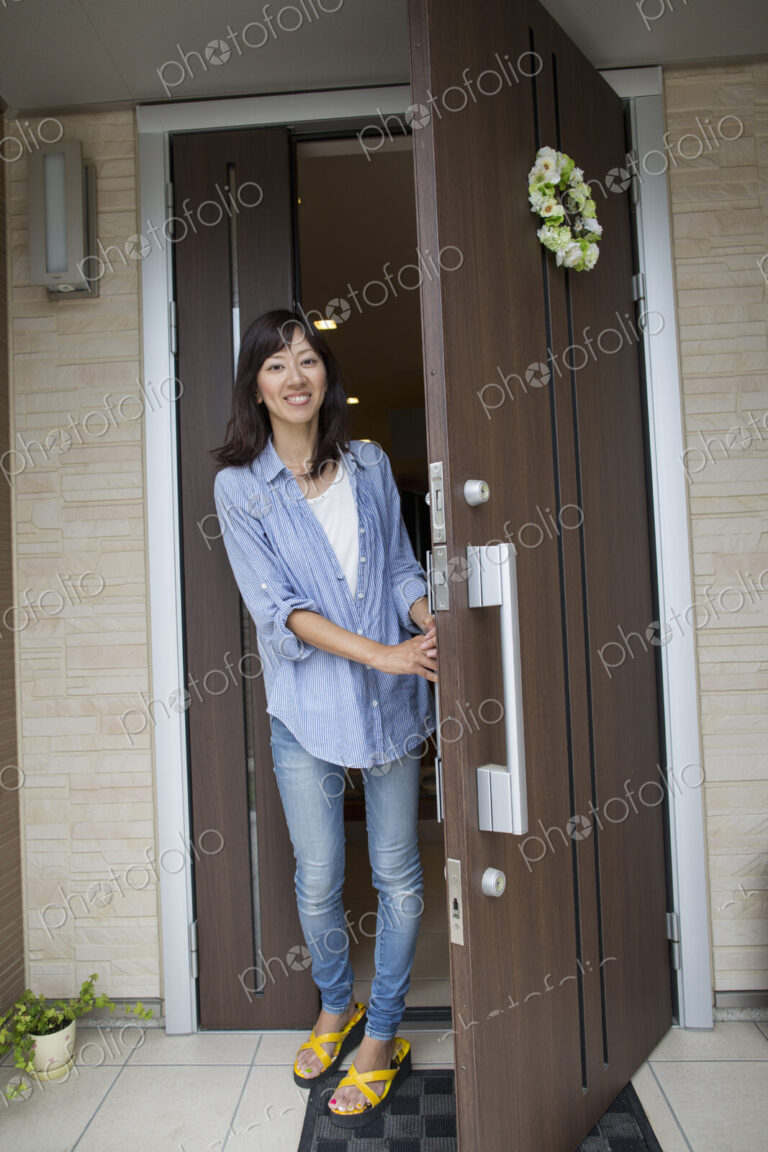 A woman standing at her front door.