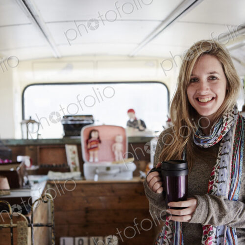 A woman standing in a bus converted into a vintage shop