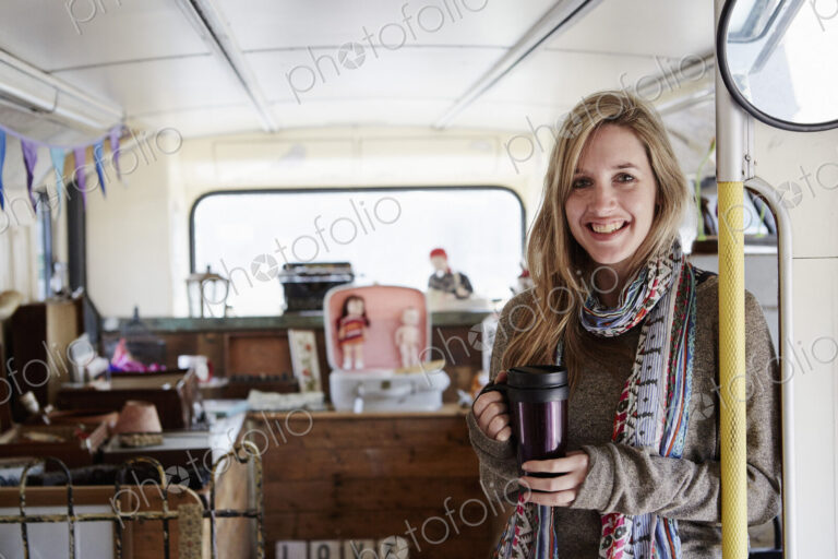 A woman standing in a bus converted into a vintage shop