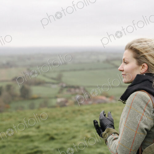 A woman standing in a hilltop looking at the view. A woman standing in a hilltop looking at the view.