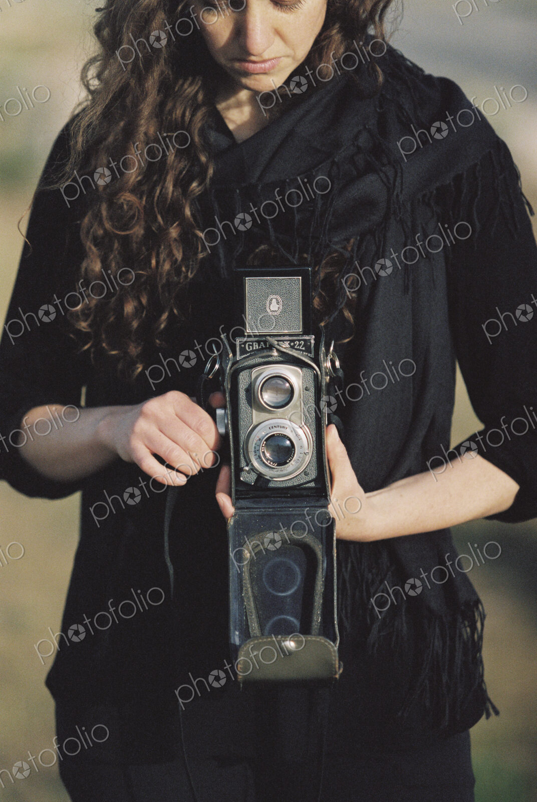 A woman taking a picture with an old fashioned medium format camera.