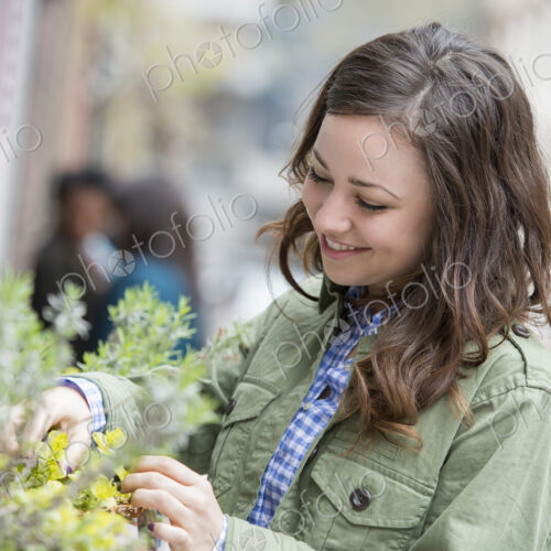 A woman tending a window box on a city street. Spring flowers. A woman tending a window box on a city street. Spring flowers.