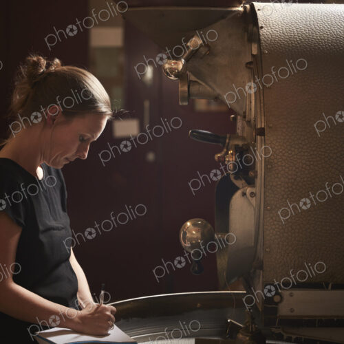 A woman testing a handful of roasted coffee beans. A woman testing a handful of roasted coffee beans.