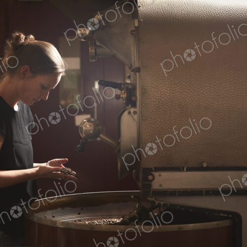 A woman testing a handful of roasted coffee beans. A woman testing a handful of roasted coffee beans.
