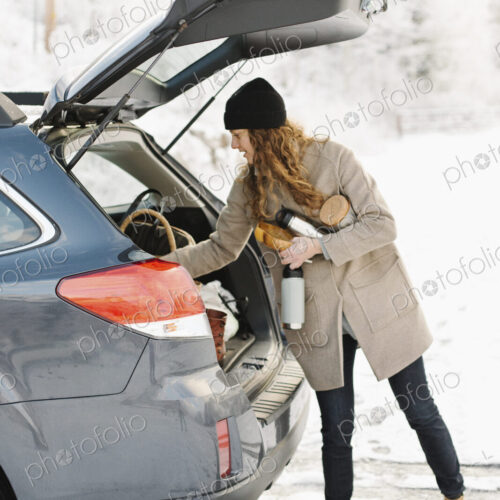 A woman unloading the shopping from the boot of a car. A woman unloading the shopping from the boot of a car.