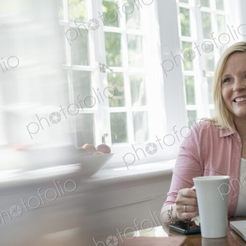 A woman using a laptop at a table, working at home. A woman using a laptop at a table, working at home.