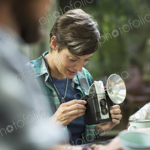 A woman using a vintage camera with separate metal flash unit. A woman using a vintage camera with separate metal flash unit.