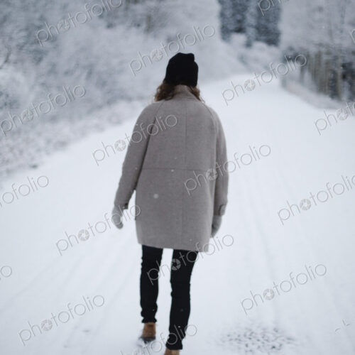 A woman walking on a snowy path. A woman walking on a snowy path.