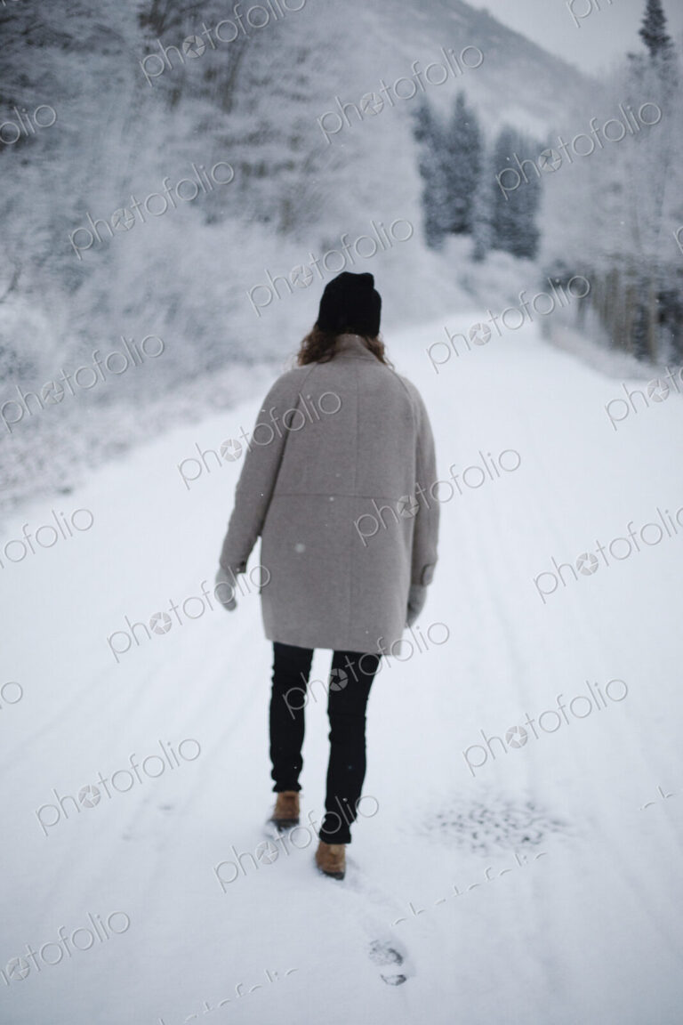 A woman walking on a snowy path.