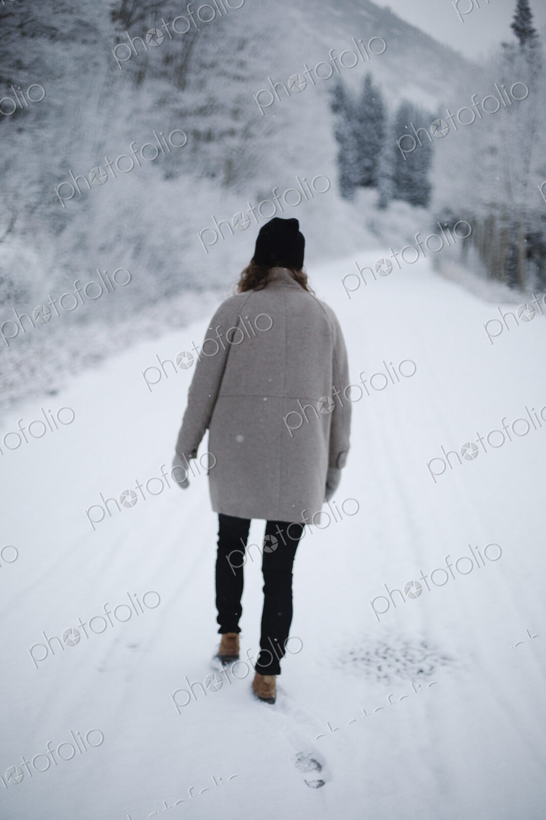 A woman walking on a snowy path.