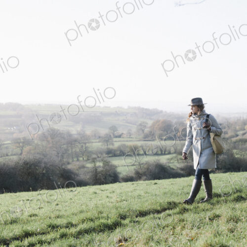 A woman walking on high ground overlooking the countryside. A woman walking on high ground overlooking the countryside.