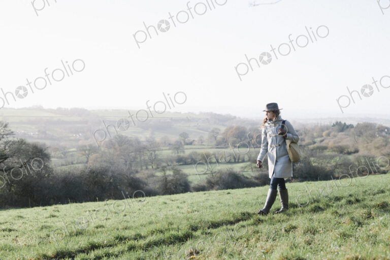 A woman walking on high ground overlooking the countryside.