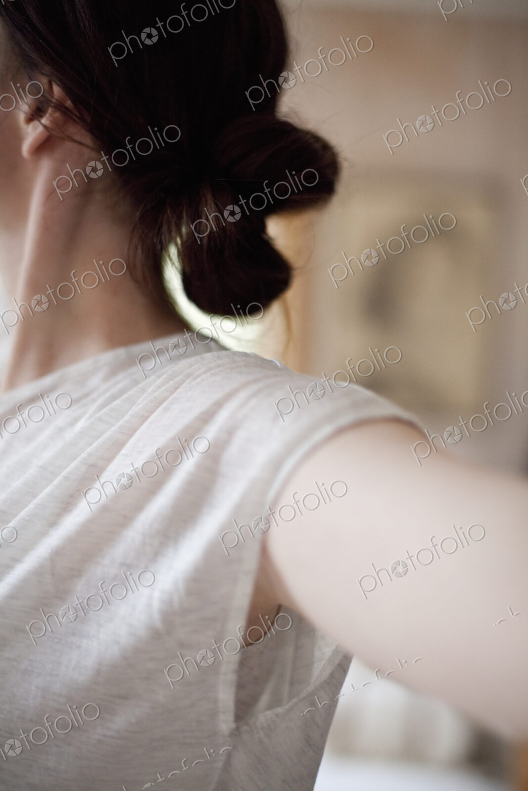 A woman wearing a light tee shirt, with her hair neatly tied back in a clip.…