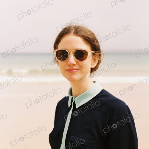 A woman wearing sunglasses on a beach. A woman wearing sunglasses on a beach.