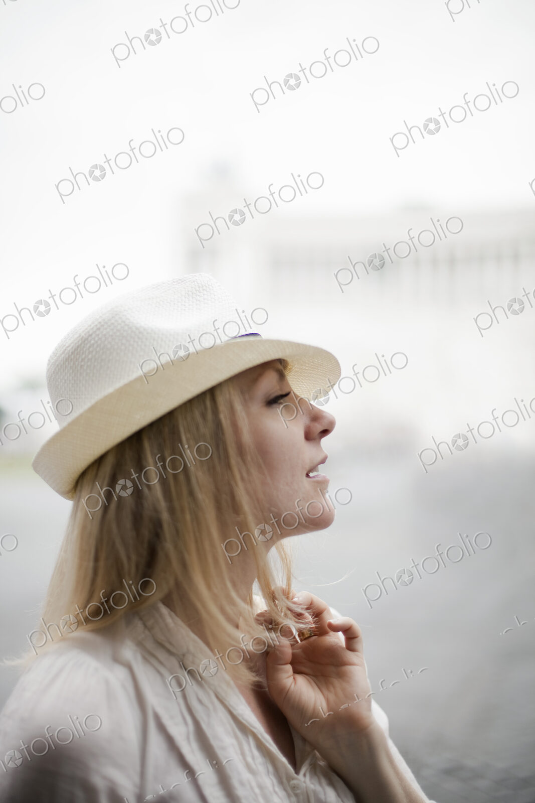 A woman with blonde hair wearing a cream panama hat.