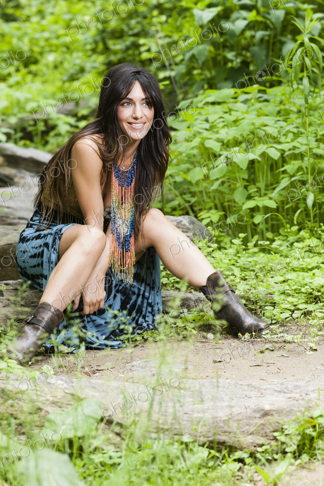 A woman with long brown hair outdoors in woodland.