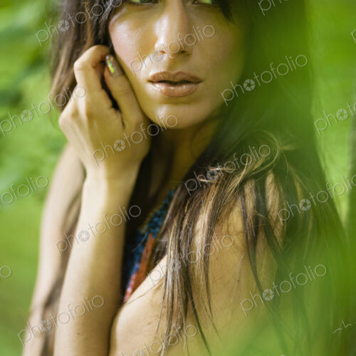 A woman with long brown hair outdoors in woodland. A woman with long brown hair outdoors in woodland.