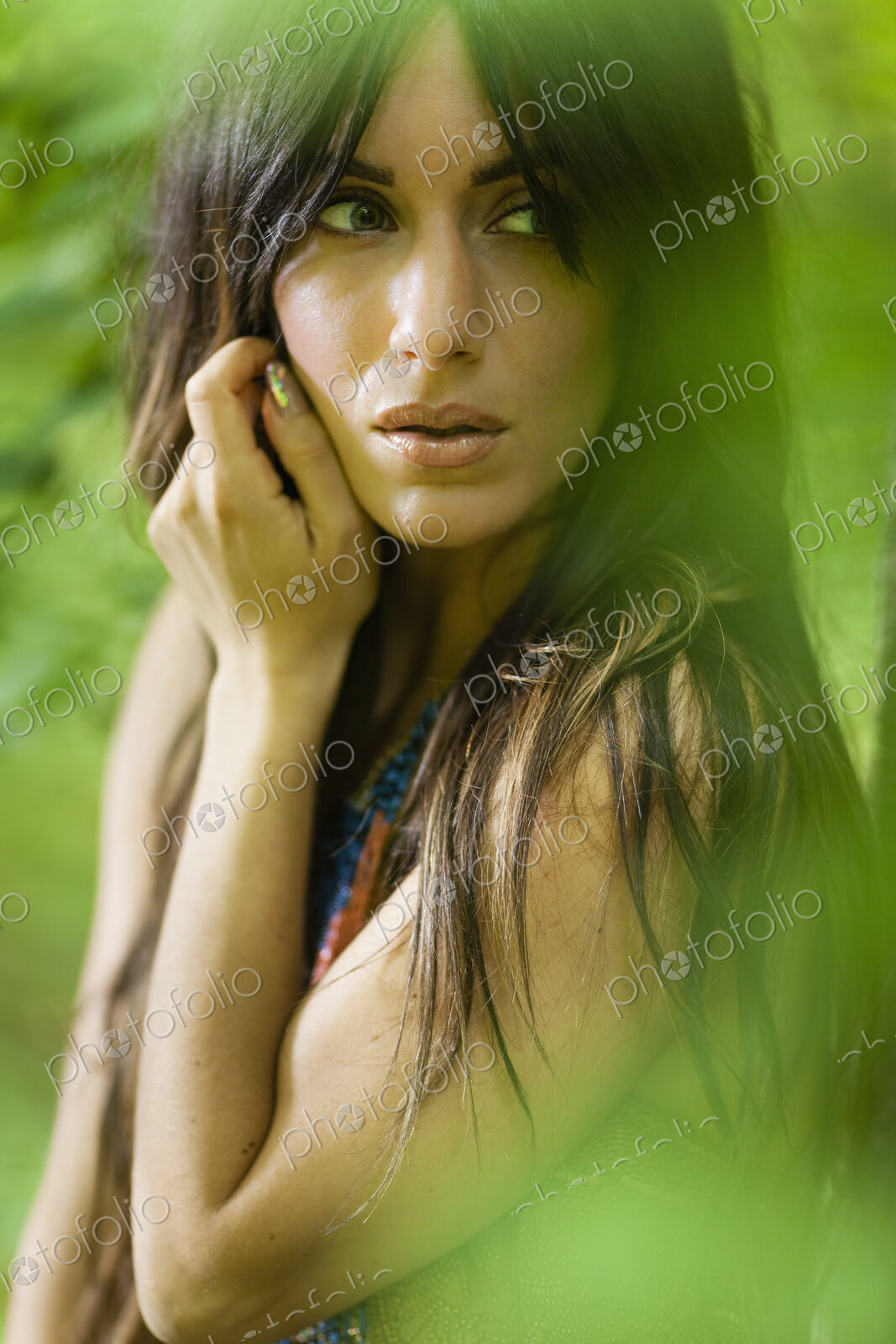 A woman with long brown hair outdoors in woodland.