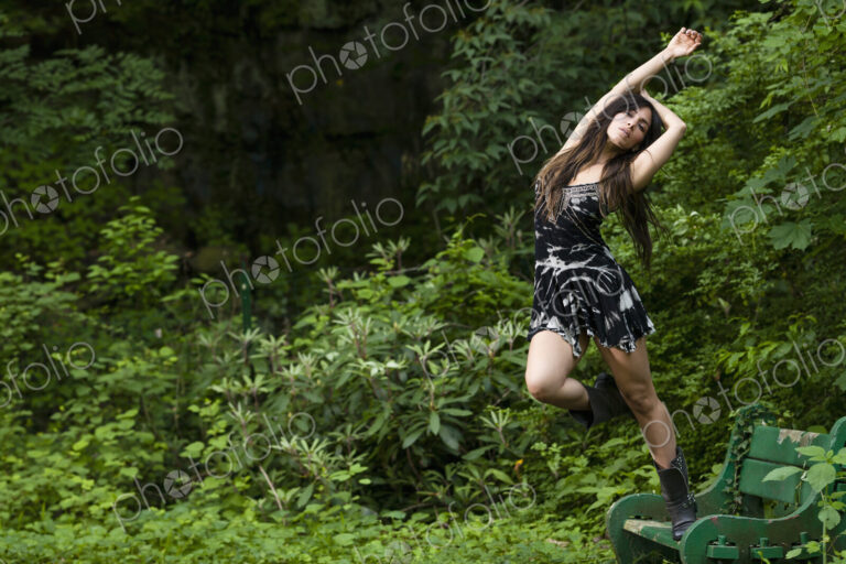 A woman with long brown hair outdoors in woodland.