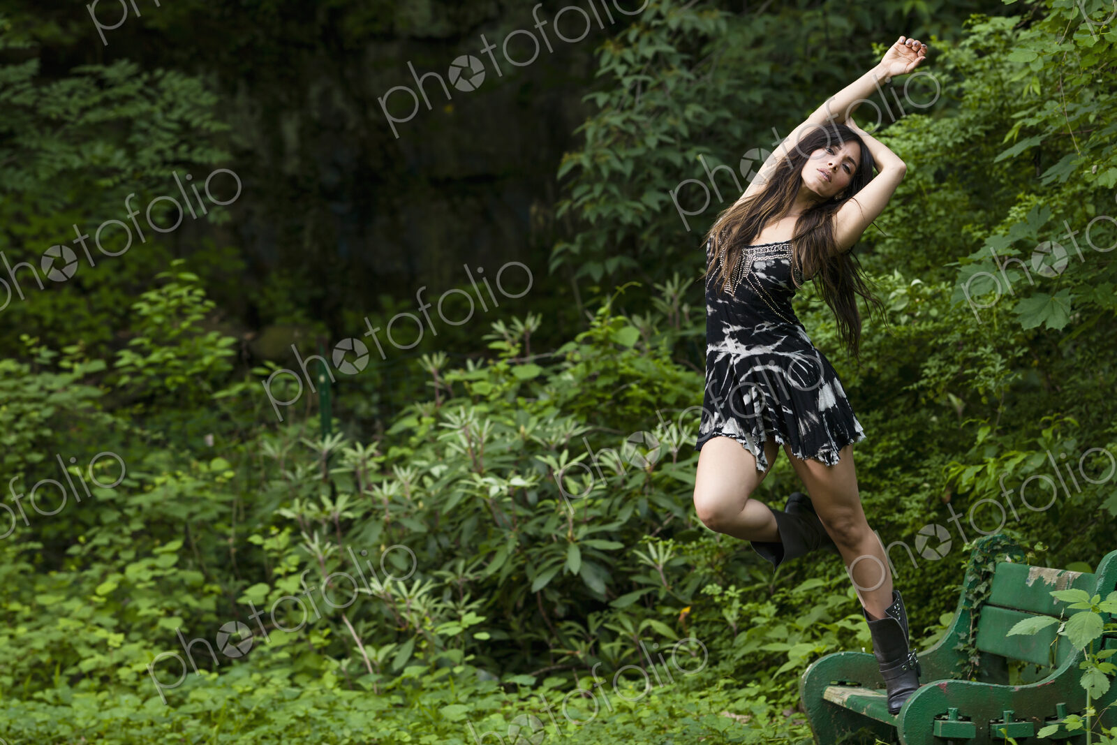 A woman with long brown hair outdoors in woodland.