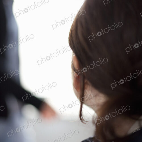 A woman with long brown hair tied back from her face. A blue jacket with the collar… A woman with long brown hair tied back from her face. A blue jacket with the collar…