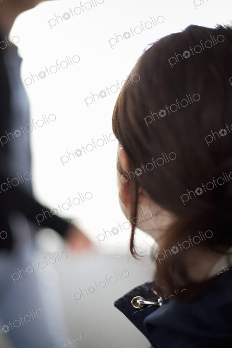 A woman with long brown hair tied back from her face. A blue jacket with the collar…