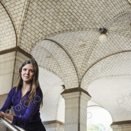 A woman with long hair standing under an arched ceiling. A woman with long hair standing under an arched ceiling.