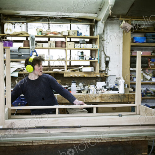 A woman working in a furniture maker's workshop, assembling a table. A woman working in a furniture maker's workshop, assembling a table.