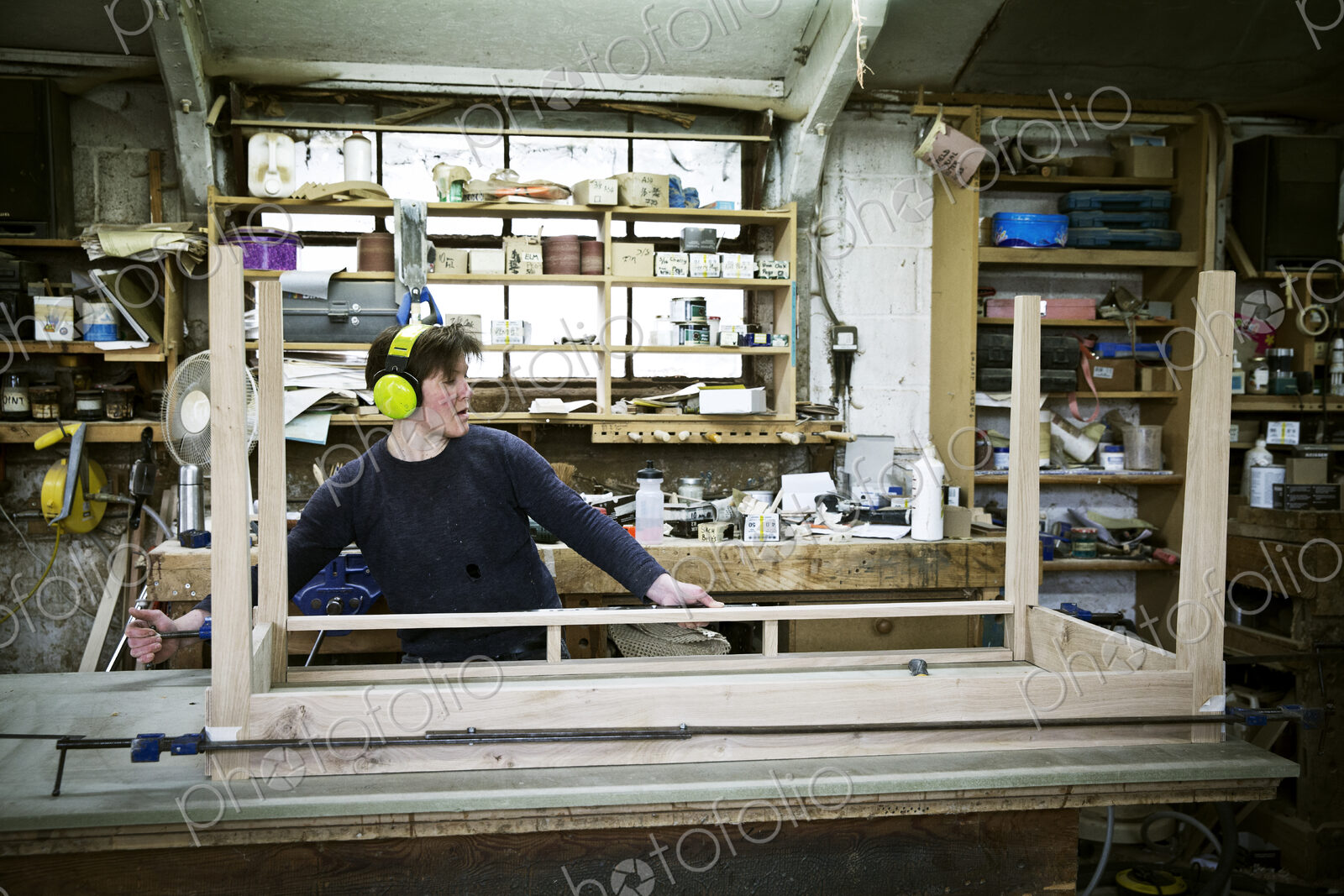 A woman working in a furniture maker’s workshop, assembling a table.