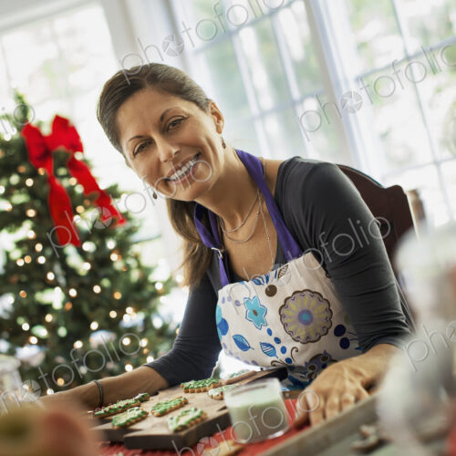 A woman working on organic homemade Christmas cookies, decorating and sprinkling… A woman working on organic homemade Christmas cookies, decorating and sprinkling…