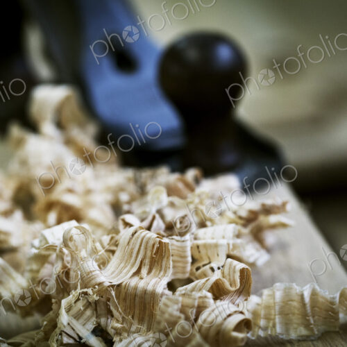 A wood plane on a piece of wood and wood shavings. A wood plane on a piece of wood and wood shavings.