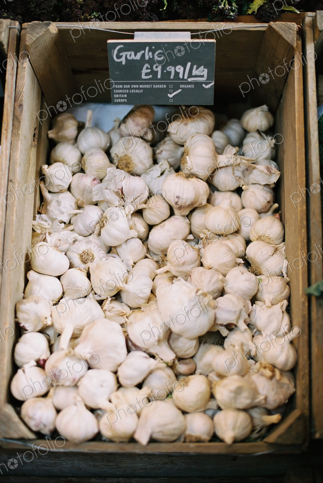 A wooden crate of garlic bulbs.