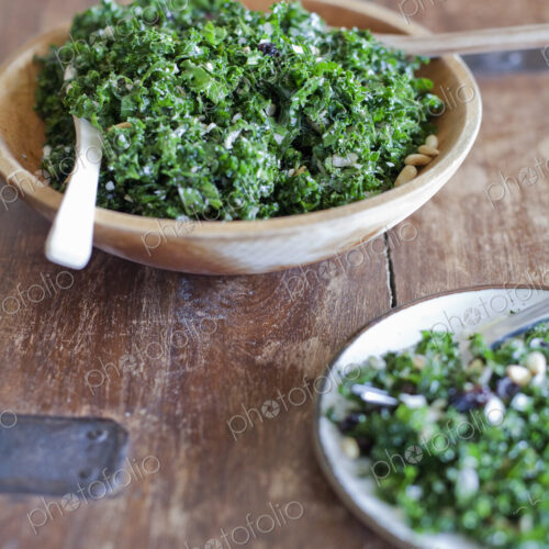 A wooden kitchen tabletop. Two plates of fresh green salad vegatables. Organic fresh food. A wooden kitchen tabletop. Two plates of fresh green salad vegatables. Organic fresh food.
