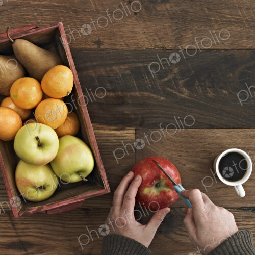 A wooden table top with variety of wood colour and grain. A box of fresh fruits, pears… A wooden table top with variety of wood colour and grain. A box of fresh fruits, pears…