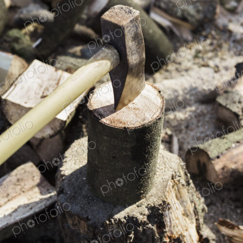A woodpile, a stack of logs and an axe wedged in a log. A woodpile, a stack of logs and an axe wedged in a log.