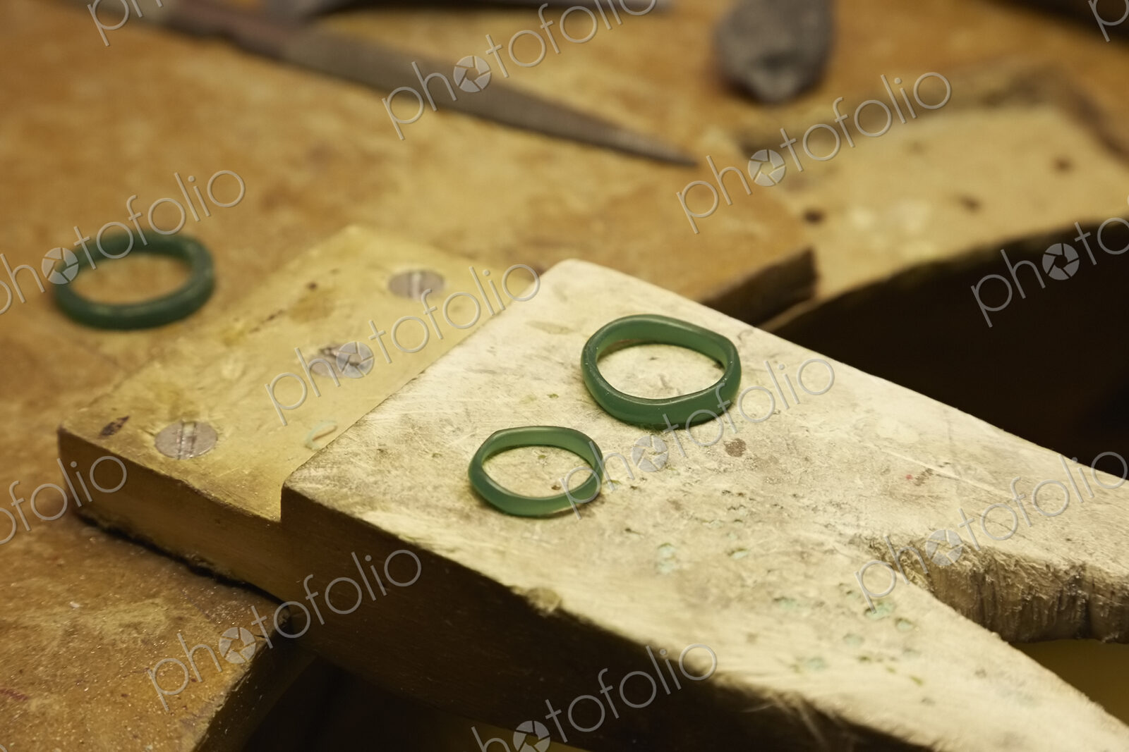 A workbench with three rings in a green material.