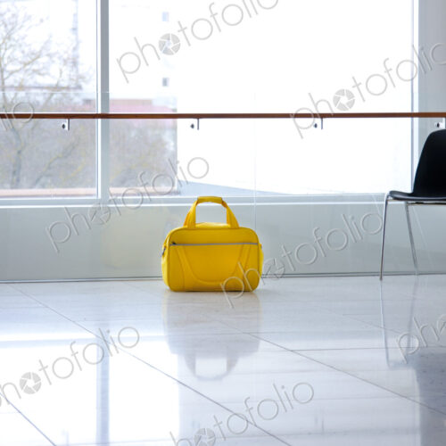 A yellow bag in a light and airy empty corridor Yellow bag. A yellow bag in a light and airy empty corridor Yellow bag.