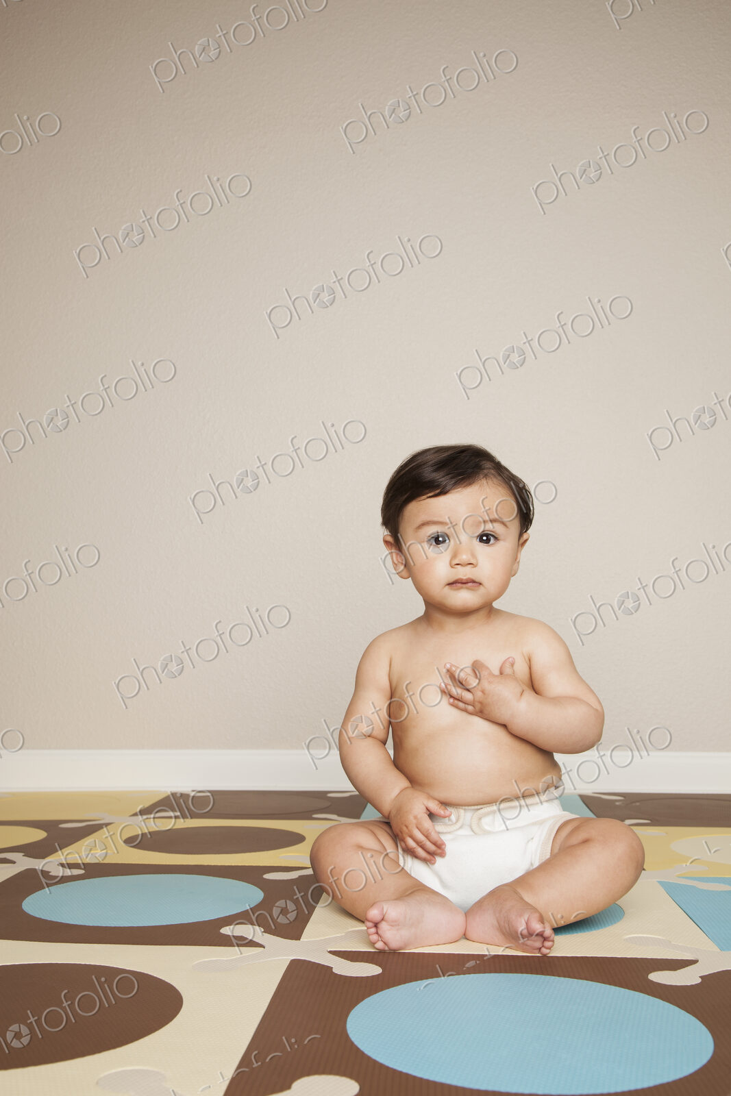 A young 8 month old baby boy wearing cloth diapers.