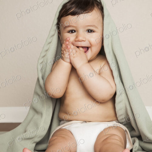 A young 8 month old baby boy wearing cloth diapers, sitting on the floor. A cot… A young 8 month old baby boy wearing cloth diapers, sitting on the floor. A cot…