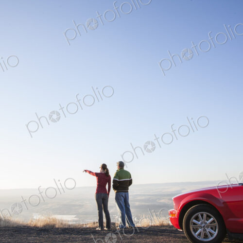 A young Caucasian couple admiring the view at a highway rest stop at dusk A young Caucasian couple admiring the view at a highway rest stop at dusk