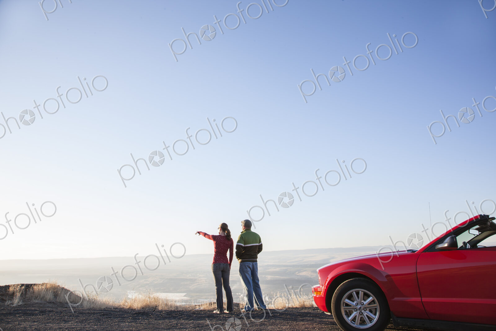 A young Caucasian couple admiring the view at a highway rest stop at dusk