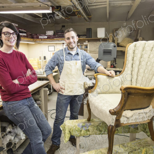 A young Caucasian couple working on a chair as a team of upholsterers. A young Caucasian couple working on a chair as a team of upholsterers.