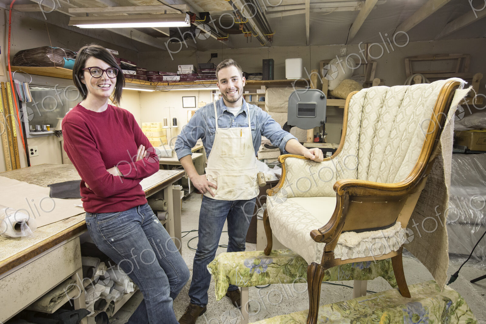 A young Caucasian couple working on a chair as a team of upholsterers.