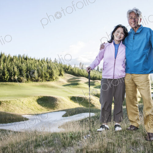 A young asian senior couple playing golf.