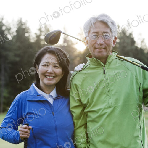 A young asian senior couple playing golf.
