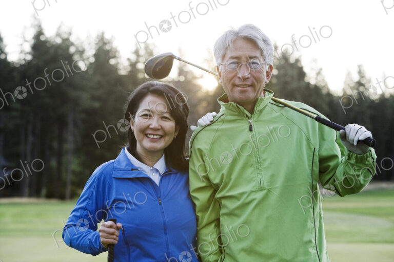 A young asian senior couple playing golf.