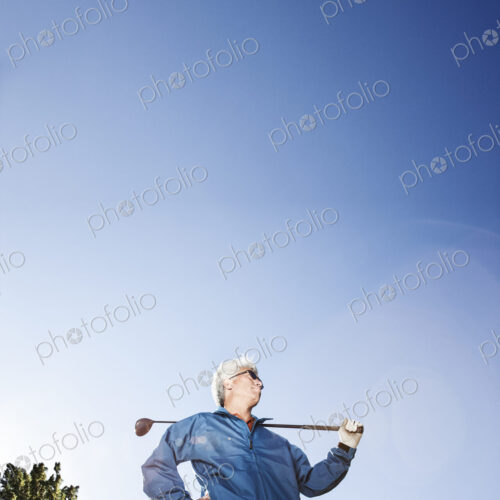 A young asian senior man ready to hit his next golf shot on a golf course.